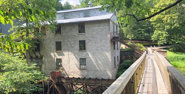 A wooden bridge leads to the historic mill at Evins Mill in Smithville