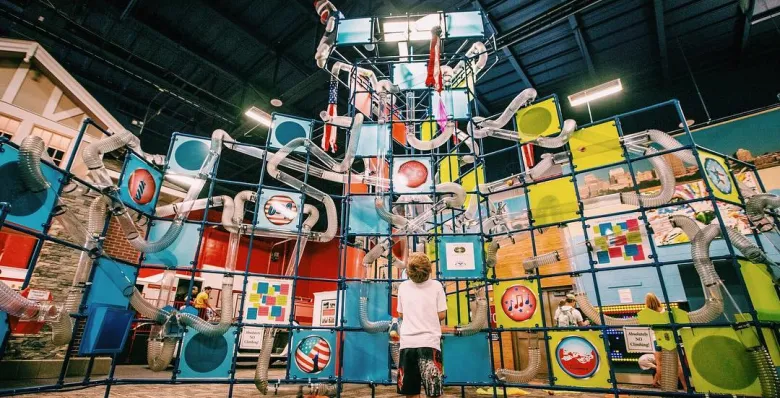 Room filled with vibrant, hanging square panels creating an immersive display at the Children's Museum of Memphis.